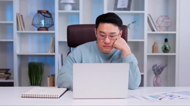 Азиатский Мужчина Очках Сидит Столом Офисе Мужчина Выглядит Скучным Грустным — стоковое видео