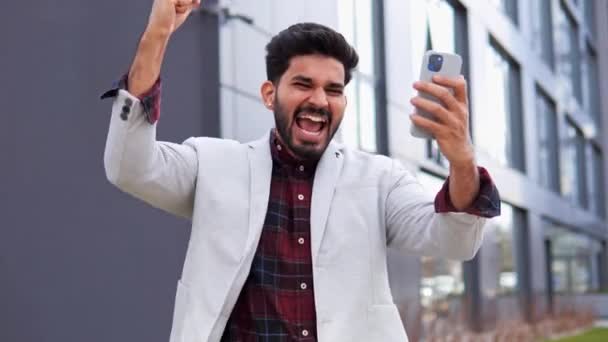 쾌활하게 사업가가 스마트폰에서 승리를 축하하고 놀라움 충격의 표정으로 사람은 받았다는 — 비디오