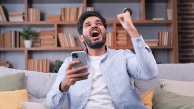 Heyecanlı Hintli iş adamı dizüstü bilgisayardaki e-postaları kontrol ediyor. Şaşırtıcı erkek kazanan yeni iş fırsatı, ödül ikramiyesi, finansal piyasa büyüme kavramını kutluyor