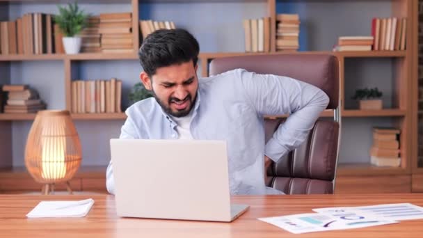 疲れ切った忙しいインドのビジネスマンは オフィスで彼のコンピュータ上で仕事をし 疲れを感じ 過労の痛みを抱えています 男は長い時間 ストレス 圧力のために彼の健康を無視します — ストック動画