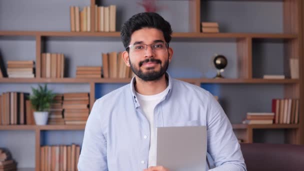 Крупный План Молодого Счастливого Индийского Бизнеса Очках Ноутбуком Смотрящим Прямо — стоковое видео