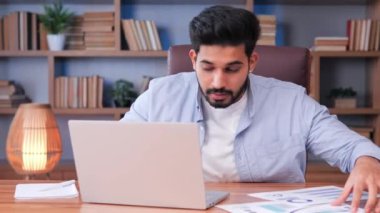 Stresli Hintli işadamı, son teslim tarihine yetişmek için mizahi bir tavırla ofis masasının etrafında koşturuyor. Adam çılgınca belgeleri topluyor, bilgisayarını kontrol ediyor, görevlerini tamamlamak için acele ediyor.