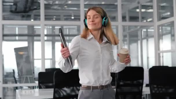 Весела Смішна Бізнес Леді Танцює Зеленими Бездротовими Навушниками Тримаючи Чашку — стокове відео