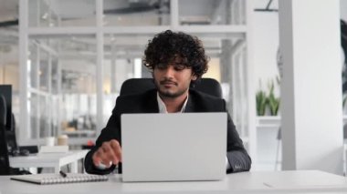 Genç Hintli İspanyol işadamı ofiste oturup notlar yazmak için bilgisayarını kullanıyor. İnternette öğrenim gören Latin öğrenci bilgisayarında sanal dijital eğitim görüyor.