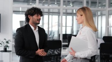 İki kültürler arası iş uzmanı gelecekteki işbirliğini görüşmek üzere bir iş toplantısındalar. Hintli adam gülümsüyor, başarılı bir DEA olduğunu gösteriyor. Beyaz gömlekli zarif iş kadını dizüstü bilgisayar tutuyor.