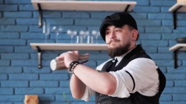 Sakallı barmen, menü ve lezzet profilleri hakkında geniş bilgiye sahip sallama veya karıştırma gibi ölçülü malzeme teknikleri kullanarak kokteyl yapıyor. İnsan mükemmel bir konukseverlik hizmeti sunar.