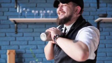 Yakışıklı, pozitif, karizmatik otantik erkek barmen lüks restoran barında bir kokteyl hazırlıyor. Beceri ve uzmanlığıyla barmen, karışık alkollü içki ve tatil partisi hazırlar.