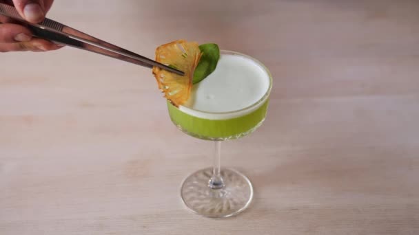 优质伏特加酒的醇厚醇香与柠檬味和菠萝的甜味交织在一起 酒保在爽口的鸡尾酒中加入了最后一片柠檬 炎热的夏天 — 图库视频影像