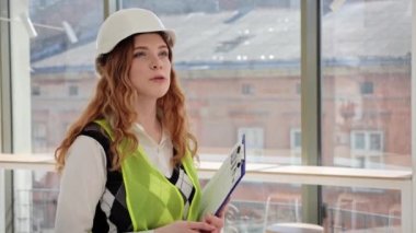 Koruyucu giysiler giyen profesyonel kadın emlakçı boş bir apartmanın potansiyel yatırımcısıyla konuşuyor. Erkek ve kadın menajeri dinliyor, satın alıyor, kiralıyor, kafe kiralıyor.