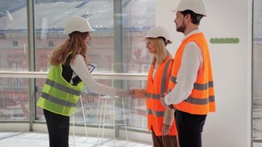 Bir emlak ajansı yöneticisi ile genç bir çift arasında restoran ya da kafe için yer kiralama, satın alma ya da satma konusunda yapılan pazarlıklar başarılı bir şekilde sonuçlandı. Kız anlaşmadan sonra el sıkışıyor.