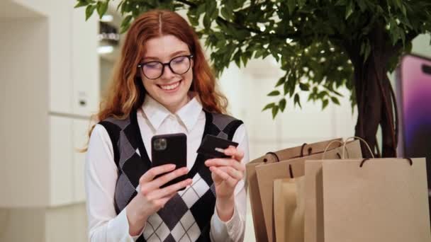 Gözlüklü Mutlu Kızıl Kız Elinde Bir Kredi Kartı Tutuyor Alışveriş — Stok video