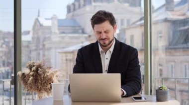 Kafede dizüstü bilgisayarla çalışan yakışıklı bir iş adamı mide ağrısı, mide ağrısı, mide iltihabı, peptik ülser, pankreas iltihabı hissediyor. Erkek programcı sindirim problemleri yaşıyor.