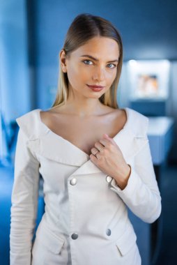 Evlatlık edinilebilecek güzel bir model bir kuyumcuda aynada durur ve kızın üzerinde parıldayan altın bir alyans dener. Kız lüks bir butikte altın mücevher ve elmaslarla süslenir.