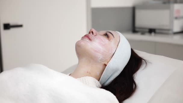 Yüzünde Beyaz Krema Maskesi Olan Şaşırtıcı Esmer Kadın Güzellik Kliniğinde — Stok video