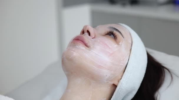 Impresionante Mujer Morena Con Una Máscara Crema Blanca Cara Reclina — Vídeos de Stock