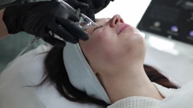 Güzel kız güzellik salonunda oksijen maskesi tedavisi görüyor. Profesyonel cilt bakımı. Enjeksiyonsuz oksijen mezoterapisinin eşsiz teknolojisi. Acı duymadan yenilikçi bir teknik.