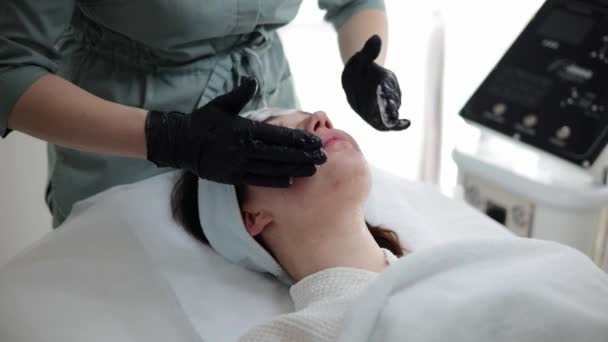 Professionell Skicklig Kosmetolog Utför Ett Terapeutiskt Ingrepp Kvinnans Ansikte Bär — Stockvideo
