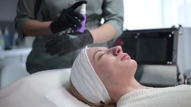 Kvinnelig Kosmetolog Hudlege Påfører Oljebasert Sprayløsning Hudcelleregenerering Skjønnhetssalongen Beroligende Maske – stockvideo