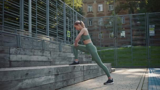 Schöne Sportliche Mädchen Macht Beinstreckungen Lehnt Sich Auf Einer Holzbank — Stockvideo