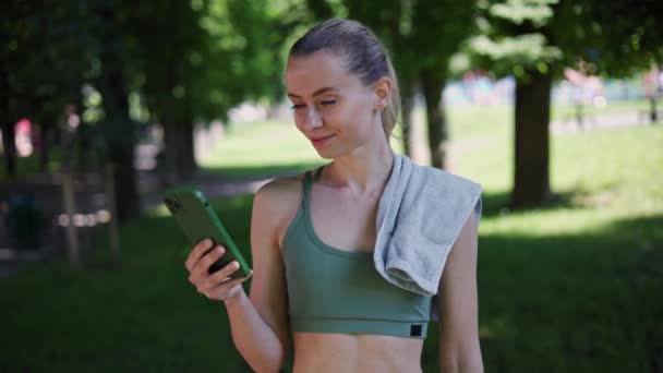 Usmívající Fit Sportovní Žena Pomocí Nové Aplikace Mobilního Telefonu Venkovním — Stock video