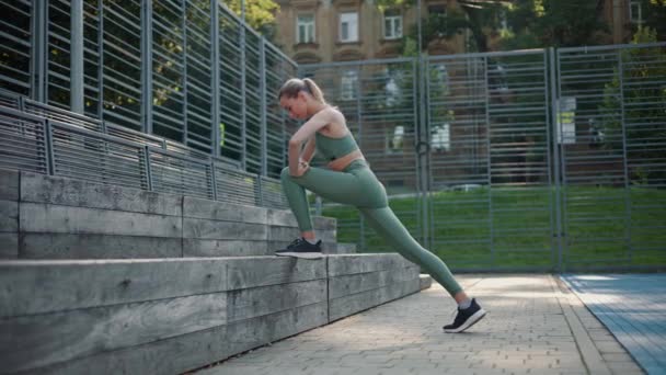Bella Ragazza Sportiva Allungamenti Delle Gambe Appoggiata Una Panchina Legno — Video Stock