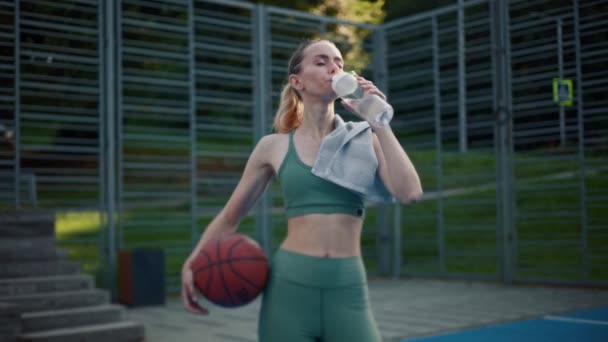 Sporcu Kadın Basketbol Maçından Sonra Kameraya Bakarak Şişeden Içiyor — Stok video