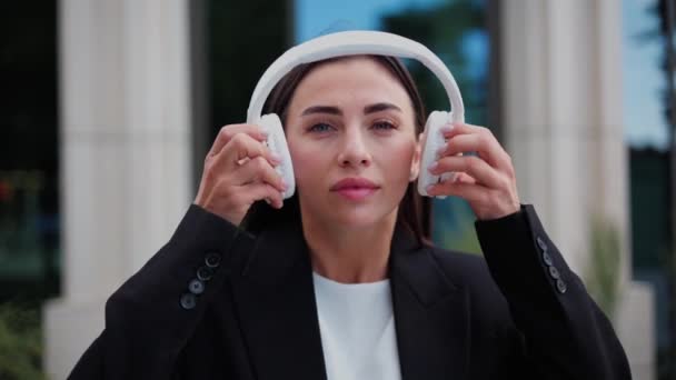 Mujer Poniendo Auriculares Disfrutando Música Ciudad Urbana Mirando Cámara — Vídeo de stock