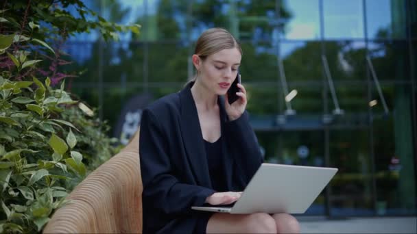 Udane Businesswoman Pisząc Laptopie Rozmawiać Telefon Komórkowy Zewnątrz — Wideo stockowe