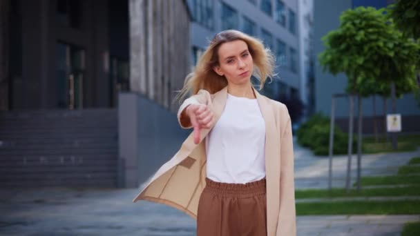 年轻的金发女人在街上用大拇指做阴性手势 — 图库视频影像