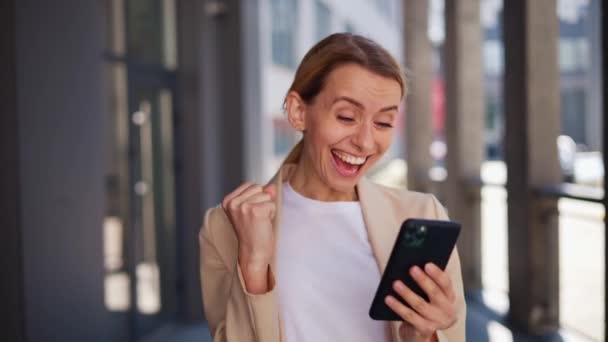 穿衣快乐的女孩在智能手机里看到好消息就会做手势 — 图库视频影像