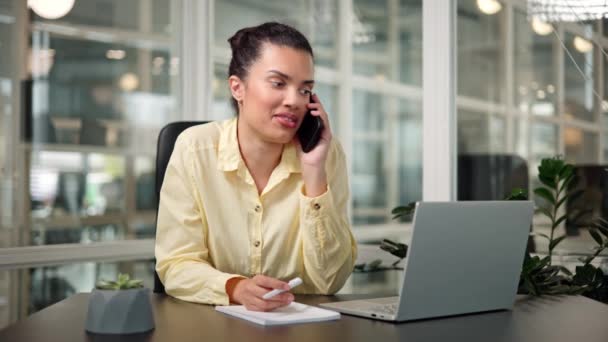 迷人的西班牙女人在办公室用智能手机远程咨询客户 — 图库视频影像
