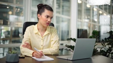 Ciddi Latin iş kadını internet kamerasıyla ofiste konuşuyor.