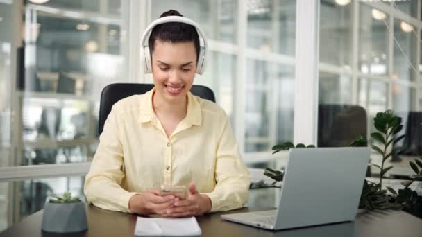 スペイン語ラテン語のオフィスワーカーがホワイトヘッドフォンで音楽を聴き 歌を歌う — ストック動画
