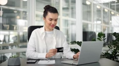Kadın kredi kartı gösteriyor. Ofis çalışanı kadın bir banka işlemini tamamladı.