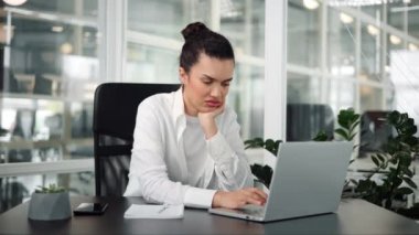 Sıkıcı nedensiz İspanyol genç kadın laptopla çalışmaktan yoruldu.