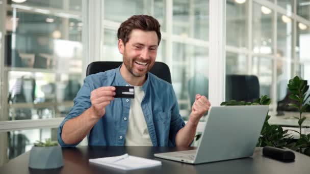 Podekscytowany Mężczyzna Biznesmen Posiadający Kartę Kredytową Patrząc Zwycięzcę Laptopa Wygrać — Wideo stockowe