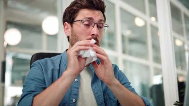 不健康な男性の従業員がオフィスで働いている間にくしゃみをする — ストック動画