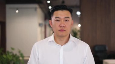 Puzzled asian director getting pissed off when hearing lame excuses from employee for bad work performance. Formally dressed ceo with concerned face expression spreading hands and angrily asking what.