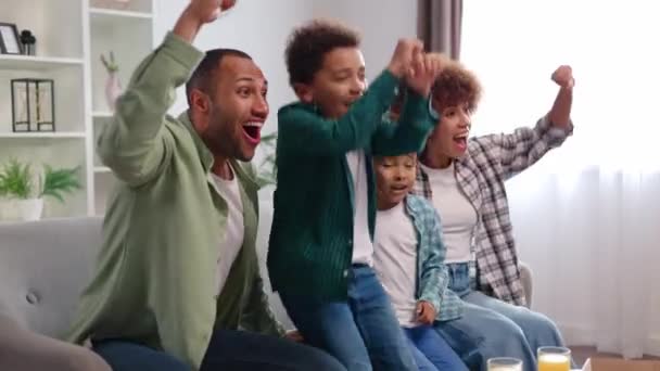 Parlak Oturma Odasında Afro Amerikan Ailesinin Maç Izlemesine Bakış Açısı — Stok video