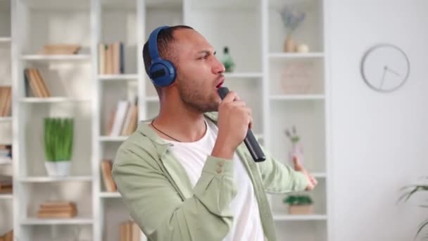 Dynamische Afro Amerikaanse Man Draagt Een Blauwe Draadloze Hoofdtelefoon Die — Stockvideo