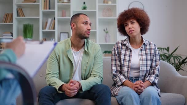 アフリカ系アメリカ人の家族がソファーに座り プロの心理学者と相談しています 明るいオフィスでの結婚療法の成功から満足を感じるポジティブな男性と女性 — ストック動画