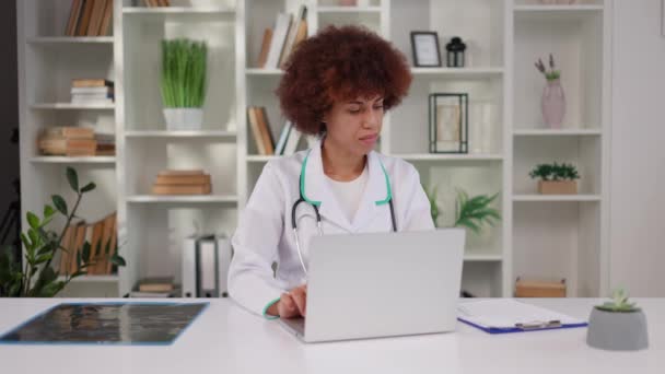 Focado Africano Americano Terapeuta Feminino Jaleco Usando Laptop Sem Fio — Vídeo de Stock