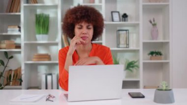 Çok kültürlü kadın ofis çalışanı gözlerinde hüsranla bilgisayar ekranına bakıyor ve elleriyle başını tutuyor. Kıvırcık saçlı genç bir kadın son teslim tarihini kaçırırken sorun yaşıyor..