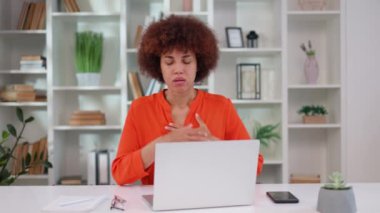 İş yerindeki panik atak sırasında nefes almakta zorlanan korkmuş genç bir bayan çalışan. Stresli Afro-Amerikalı kadın, portatif bilgisayarla masada otururken göğsünü tutuyor..