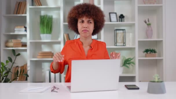坐在现代办公室时 多种族的黑头发女人在突然腰痛时感到不适 疲惫的年轻女士穿着橙色的衬衫做一些运动来缓解疼痛 — 图库视频影像