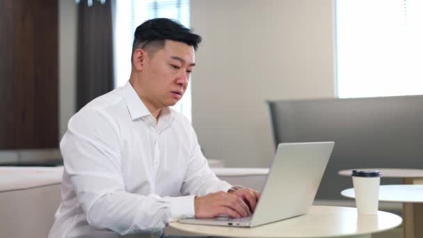 在工作场所和使用无线计算机时 亚洲员工经历了情绪倦怠 身穿官方服装的不快乐绅士 没有动力继续从事令人憎恨的工作 — 图库视频影像