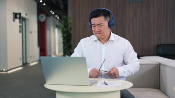 Sikeres Férfi Vállalkozó Hallgat Dalt Vezeték Nélküli Fejhallgató Nézi Laptop — Stock videók