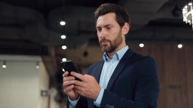 Orta yaşlı, güzel esmer bir adam iş yerinde kalırken cep telefonundan mesaj atıyor. Resmi olarak giyinmiş girişimci iş için randevu zamanı ve tarih hakkında bilgi gönderiyor.