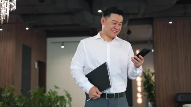Fröhlicher Asiatischer Geschäftsmann Der Freudige Gefühle Ausdrückt Während Nachrichten Auf — Stockvideo