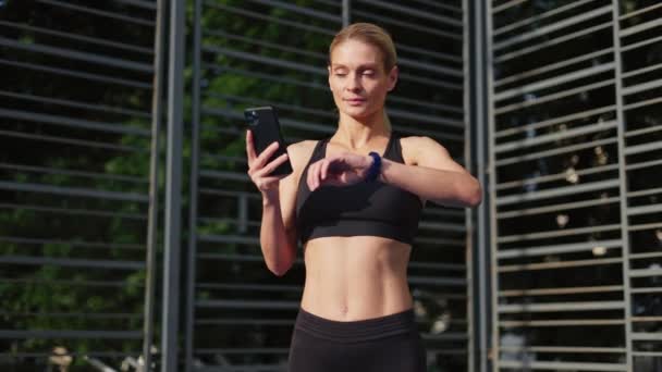 Young Blonde Athlete Using Fitness Tracker App Smartwatch Cellphone While — Stock Video
